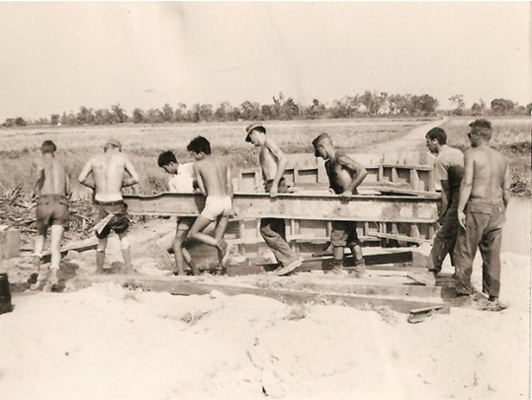 Seabees with Seabee Team and Vietnamese carry 300 pound 10 inch steel I beam