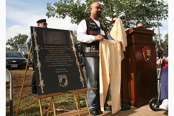 Former Iraq Campaign POW U.S. Army Spc. Joseph Hudson presents his former POW attire that he donated