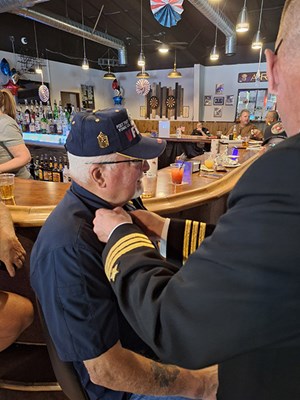 VWC Chief, Public Engagement, Cmdr. Brian Wierzbicki, U.S. Navy, pins a Vietnam veteran. 