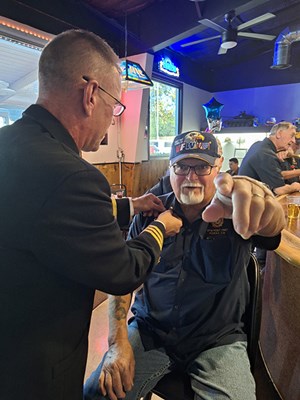 VWC Chief, Public Engagement, Cmdr. Brian Wierzbicki, U.S. Navy, pins a Vietnam veteran. 