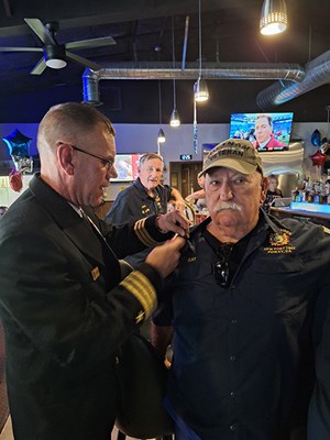 VWC Chief, Public Engagment, Cmdr. Brian Wierzbicki, USN, pins a Vietnam veteran. 
