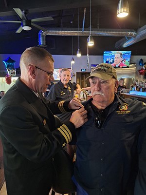 VWC Chief, Public Engagement, Cmdr. Brian Wierzbicki, U.S. Navy, pins a Vietnam veteran. 