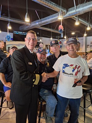 VWC Chief, Public Engagerment, Cmdr. Brian Wierzbicki, USN, stands with the Vietnam veterans.