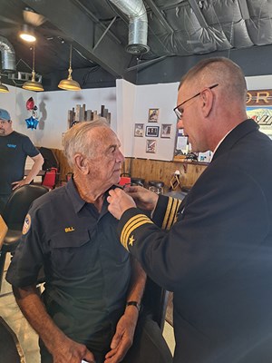 VWC Chief, Public Engagement, Cmdr. Brian Wierzbicki, USN, pins a Vietnam veteran. 