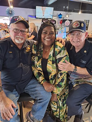 VWC Social Media Manager Charlita Wiley, takes a photo with two Vietnam veterans.