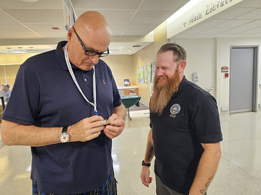 A Vietnam veteran poses with a VWC staff member after receiving a VVLP.