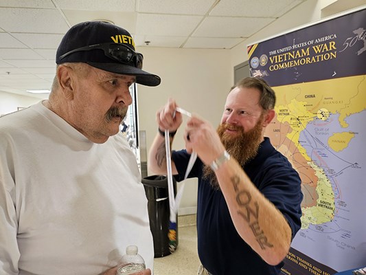 A Vietnam veteran receives a VVLP from a VWC staff member.