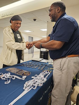 A VWC staff member shakes hands with a Vietnam veteran.