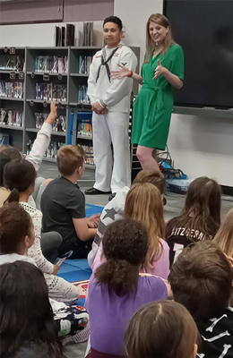 Nikki Stratton and Petty Officer 2nd Class Romero speak to 4th graders.