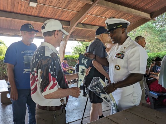 Navy personnel give out Navy items to veterans.
