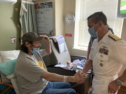Rear Adm. Douglas G. Perry shakes the hand of a veteran.