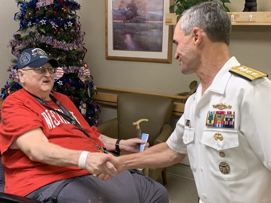 Rear Adm. Douglas G. Perry shakes the hand of a veteran.