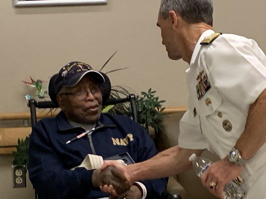Rear Adm. Douglas G. Perry shakes the hand of a veteran.