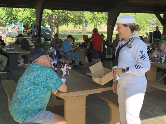 Navy service member speaks with a veteran.