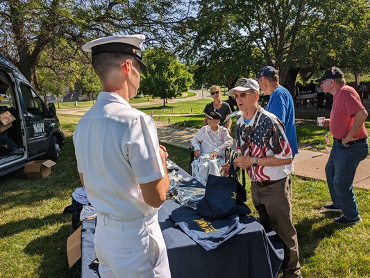 Navy personnel speak with veterans.