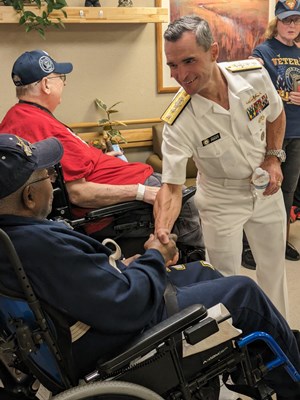 Rear Adm. Douglas G. Perry shakes the hand of  a veteran.