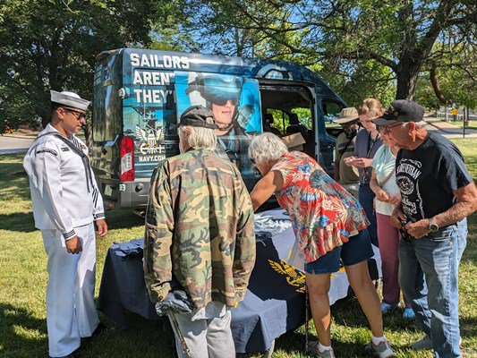 Navy personnel prepare a tabletop display.