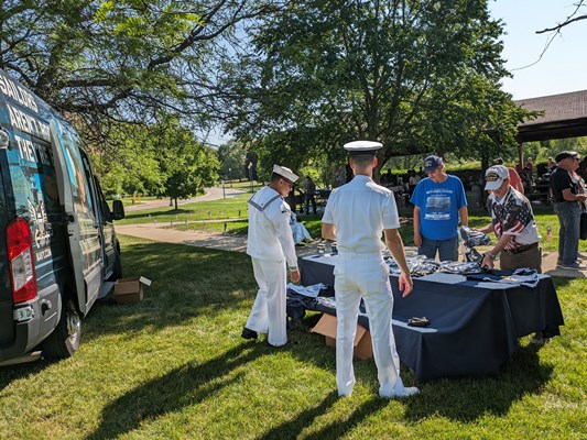 Navy personnel prepare tables for the cookout.