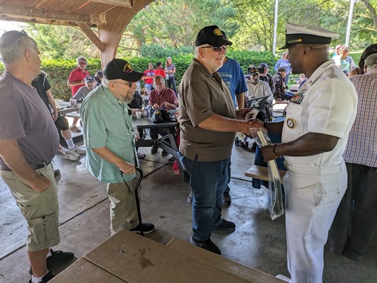 Vietnam veterans receive Navy items from Navy personnel