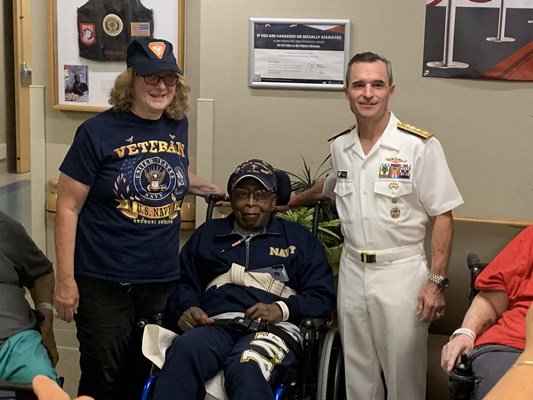 Rear Adm. Douglas G. Perry takes a photo with a veteran.