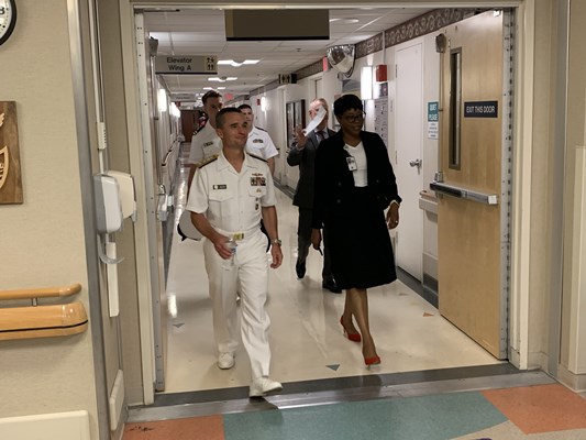 Rear Adm. Douglas G. Perry walks the halls of the veterans home with administrators.