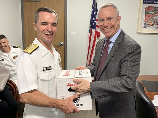 Rear Adm. Douglas G. Perry is presented with a case of root beer. 