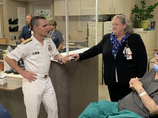 Rear Adm. Douglas G. Perry speaks to an administrator.