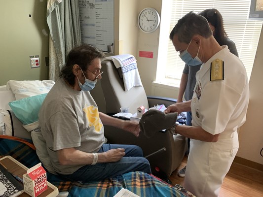 Rear Adm. Douglas G. Perry visits a veteran.