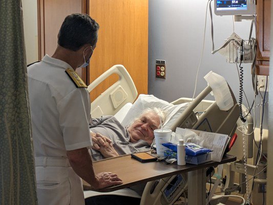 Rear Adm. Douglas G. Perry visits a veteran.