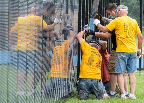 Volunteers and staff help assemble The Wall That Heals