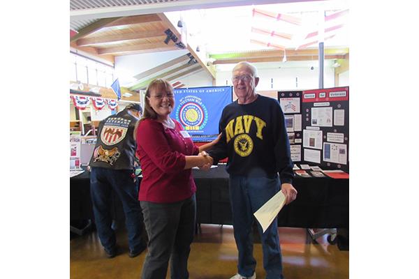 Champoeg Chapter NSDAR regent Jan Burrows shakes hands with Navy veteran Bob Herbst.