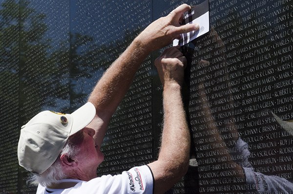 Veteran traces name of fellow veteran.