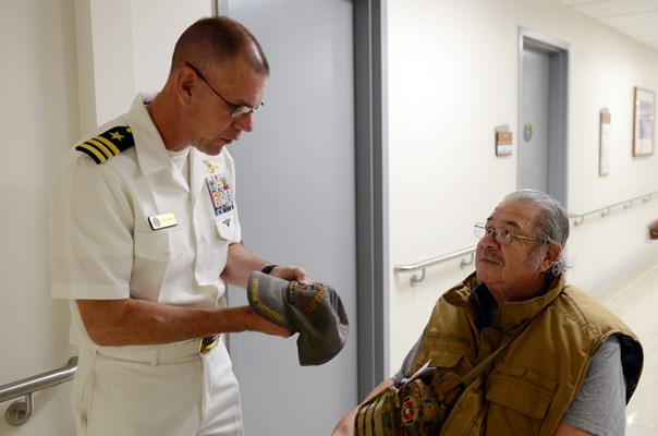 VWC's Cmdr Brian Wierzbicki pins a VVLP on the cap of a Vietnam veteran.