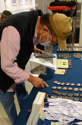 A Vietnam veteran gathers informative materials from the VWC display table. 