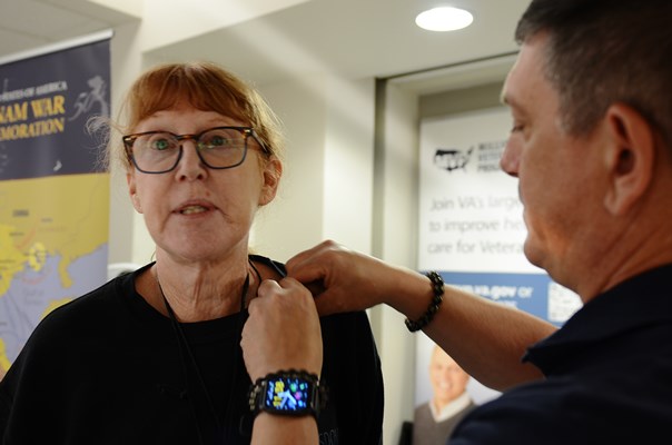 A VWC staff member pins a VVLP on a Vietnam veteran.