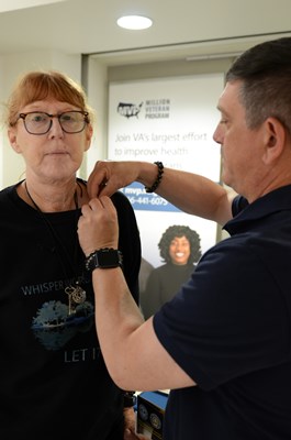 A VWC staff member pins a VVLP on a Vietnam veteran.