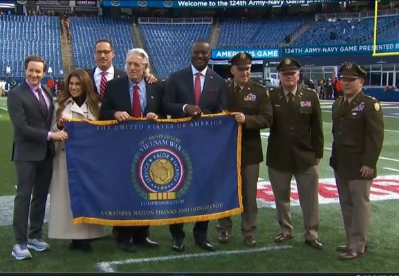 The Commemorative Flag is presented to officials from the CBS Sports Network.