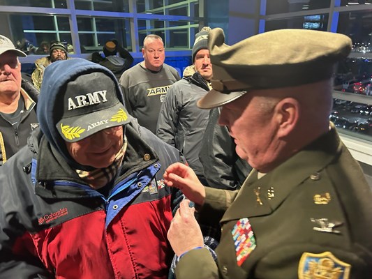 U.S. Army Col. Patrick Cramer, pins a Vietnam veteran.