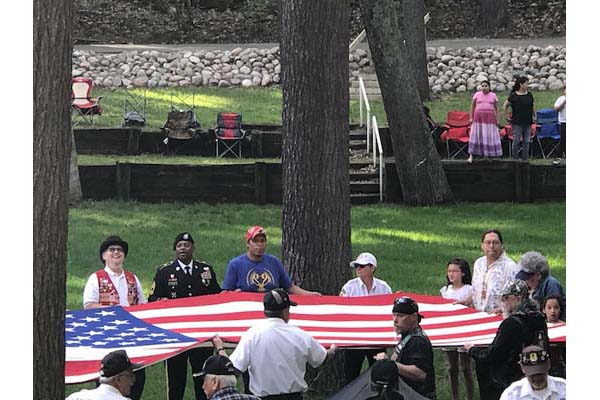 Flag-raising in honor of fallen heroes in a outdoor amphitheater in the Menominee Nation.
