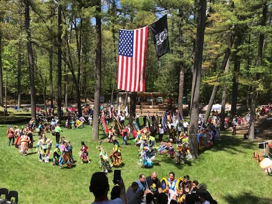 Flag-raising in honor of fallen heroes in a outdoor amphitheater in the Menominee Nation.