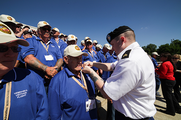 Army Sgt. Mike Parker presents a Vietnam Veteran Lapel pin to a veteran. 