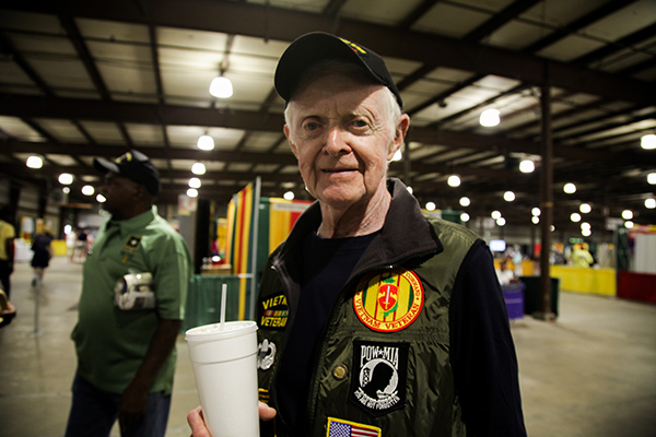 - A Vietnam veteran poses for a photo while visiting the Vietnam War Commemoration display booth.