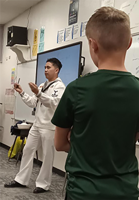 Petty Officer 2nd Class Romero speaks to 4th graders.
