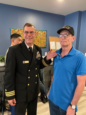 Cmdr. Brian Wierzbicki, U.S. Navy, VWC Chief, Public Engagement, stands beside the Vietnam veteran h