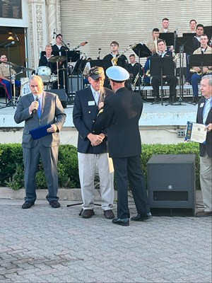 Photo of Cmdr. Brian Wierzbicki, U.S. Navy, and Chief, Public Engagement, presents a VVLP.