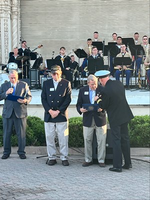 Photo of Cmdr. Brian Wierzbicki, U.S. Navy, and Chief, Public Engagement, presents a VVLP.