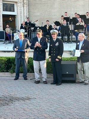 Photo of Cmdr. Brian Wierzbicki, U.S. Navy, and Chief, Public Engagement, presents a VVLP.