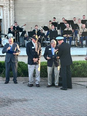 Photo of Cmdr. Brian Wierzbicki, U.S. Navy, and Chief, Public Engagement, presents a VVLP.