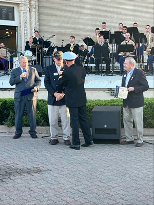 Photo of Cmdr. Brian Wierzbicki, U.S. Navy, and Chief, Public Engagement, presents a VVLP.