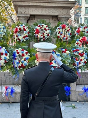 A U.S. Marine serviceman salutes at a Veterans Memorial